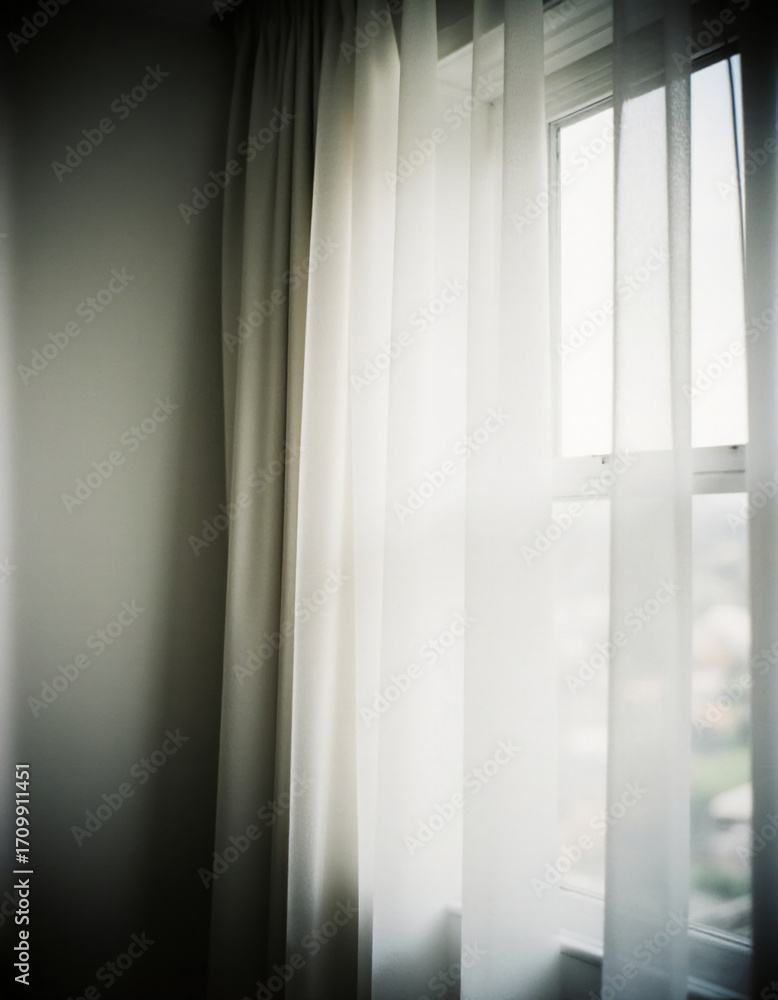 Poster soft grey curtains gently sway as daylight seeps in, creating a calm atmosphere in a cozy room with 