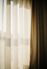 Soft, natural light shines through sheer beige curtains, creating a warm and inviting atmosphere in a peaceful room during daytime Generative AI