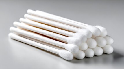 Stack of white cotton swabs. The swabs are white and are stacked on top of each other