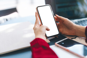 Woman hand using smartphone typing message blank screen mobile phone for mock up
