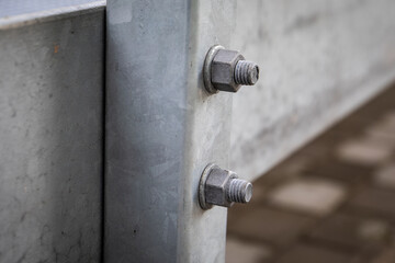Close up of galvanized steel beam connection with visible bolts and nuts showing industrial construction detail, strong metal structure