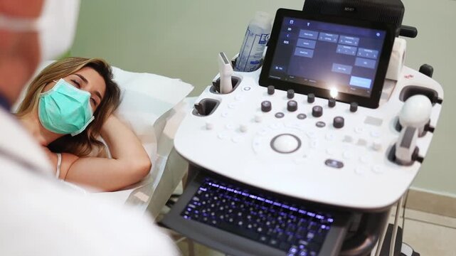 Cardiologist performing an echocardiogram on a female patient wearing a surgical mask, using ultrasound technology to assess heart health in a modern clinic