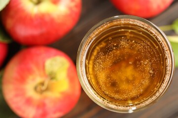 Delicious cider in glass and apples on table, flat lay