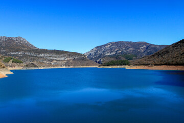 Fototapeta premium Blue reservoir lake surrounded by mountains