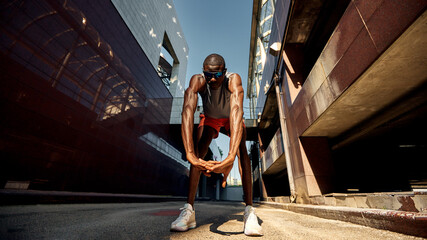 Athlete stretching outdoors in a modern urban city environment
