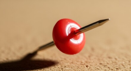 A Single Red Pushpin in Sharp Macro Detail, Casting a Dramatic Shadow on a Corkboard.