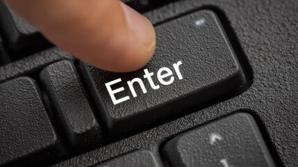 Finger presses the "Enter" key on a keyboard