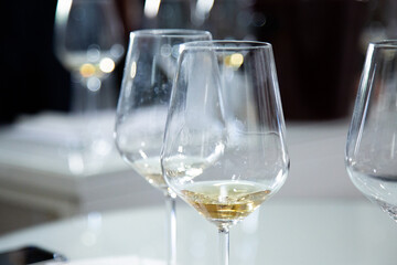 On the table sit three wine glasses filled with white wine