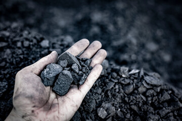 Black coal in hand. Thermal energy industry. Heating. Mineral raw materials. Natural energy stones.
