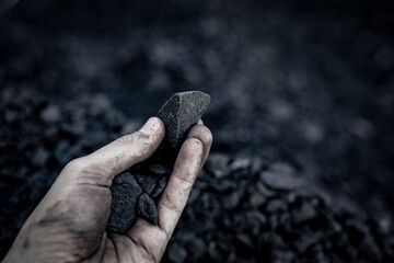 Black coal in hand. Thermal energy industry. Heating. Mineral raw materials. Natural energy stones.