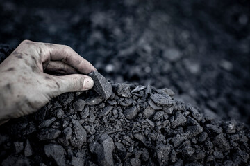 Black coal in hand. Thermal energy industry. Heating. Mineral raw materials. Natural energy stones.