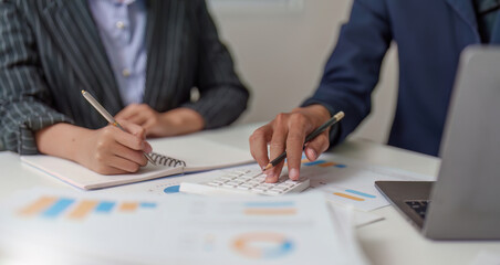 Financial Analysis. Business professionals collaborating on budget calculations using a calculator.