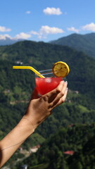 Woman Holding Cocktail with Scenic View in Background