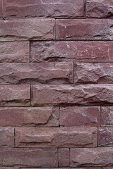 Rough brown stone and red brick wall with textured surface