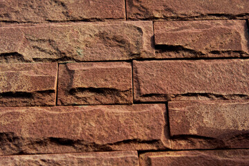 Obraz premium Rough red brick masonry forms an old, textured wall, showcasing a classic pattern of weathered blocks