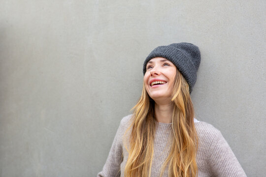Portrait happy woman with beanie looking up