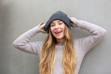 Portrait playful woman adjusting beanie and smiling