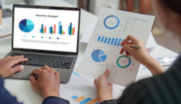 Budget Planning. Professionals analyzing monthly budget with financial reports and laptop.
