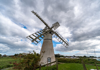 Fototapeta premium The historic windmill nestled among the reeds in the Norfolk marshes