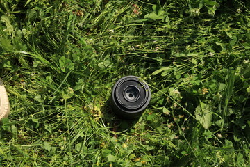 Camera Lens Placed on Grass Outdoors