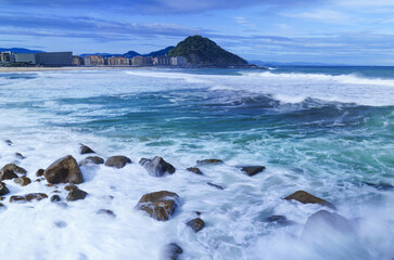 From the Sagüés viewpoint, waves crash powerfully against the coast of Donostia-San Sebastian, painting Zurriola beach with their foam, Basque Country.