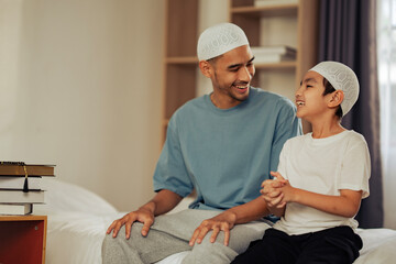 Obraz premium Father and son in Islamic attire sharing a heartfelt conversation, showing family unity, cultural identity, and religious values for education, faith, and cultural organizations.