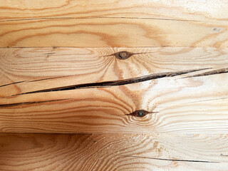 Fototapeta premium The appearance of cracks on logs during the construction of a house.