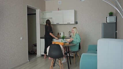 young girl getting a bowl of different size from kitchen shelf to give to sibling seated at table while they prepare for breakfast in cozy home kitchen, family interaction, morning routine - Powered by Adobe