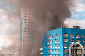 Thick smoke engulfing residential buildings creates a dramatic scene after a fire incident, emphasizing the destructive power of fire and the importance of fire safety measures