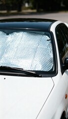 Obraz premium Close-up of a white car with a sunshade on the windshield. 