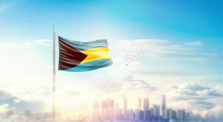 The Bahamas flag wavering in beautiful clouds with building skyline. The flag with drone shot in beautiful sky. The Bahamas national flag for independence day.