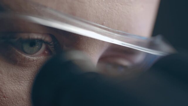 Female virologist scientist using microscope in laboratory. Biochemical and medical research. Pharmacist specialist working with lab equipment analyzing samples and searching for vaccine development
