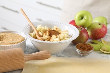 Making delicious apple strudel. Different ingredients and rolling pin on white marble table in kitchen, closeup