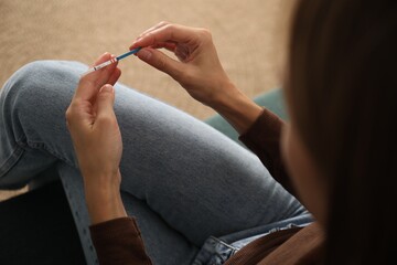 Woman with positive pregnancy test indoors, closeup