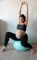 Pregnant woman stretching on fitness ball: prenatal exercises for a healthy pregnancy