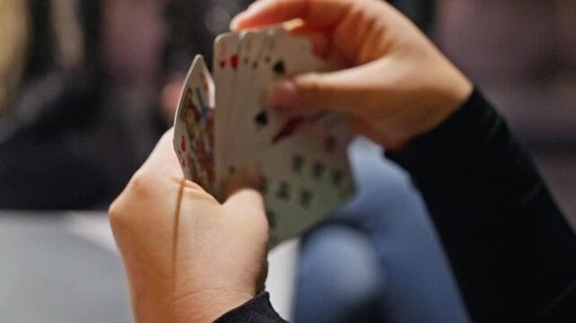 An engaging scene of a card game featuring players intensely focused on their hands, filled with various cards