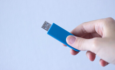 usb flash drive in hand isolated on neutral light-blue background