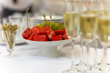Festive table with sweet snacks, fruits, and champagne flutes