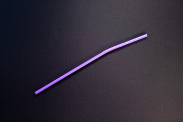 Single Purple Plastic Drinking Straw on Black Background