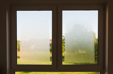 Open window view with outdoor condensation and garden landscape