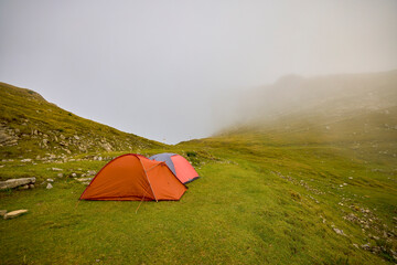 Obraz premium two tents camped in a mountain landscape on a foggy day