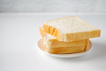 White sliced bread stacked on the white wooden table