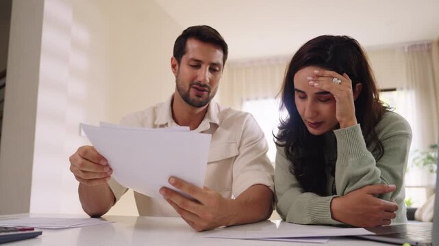 Couple overwhelmed by overdue bills and low income, facing economic stress and inflation-related financial crisis