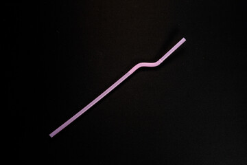 Single Purple Plastic Flexible Drinking Straw on Black Background