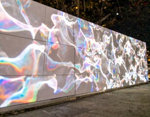 Colorful abstract display on a large wall at night