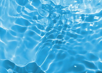 Abstract blurred shades of blue water background. Light and shadow ripples or splashes surface of water texture. Water waves with shining and reflection pattern photography for​ design artwork.