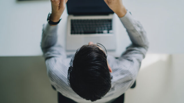 Overhead view of a focused person working at a minimalist desk with soft natural lighting. - Powered by Adobe