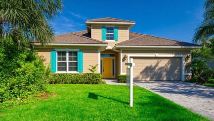 Fototapeta premium House for sale with yellow door turquoise shutters garage and palm trees