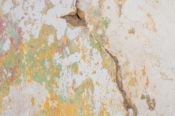 Cracked wall with peeling colorful paint