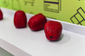 Showcasing a group of vibrant red fruits set against a clean, white backdrop. These textured specimens, isolated in a white background, make for a visually striking still life.